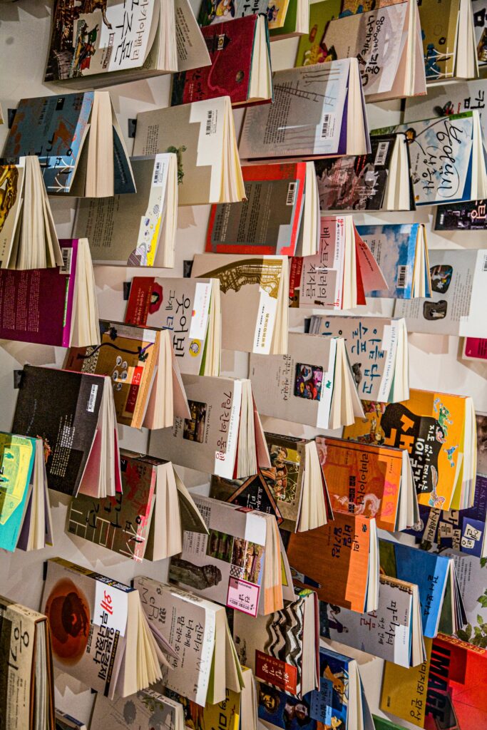 Vertical display of Korean books with vibrant covers arranged on a wall.